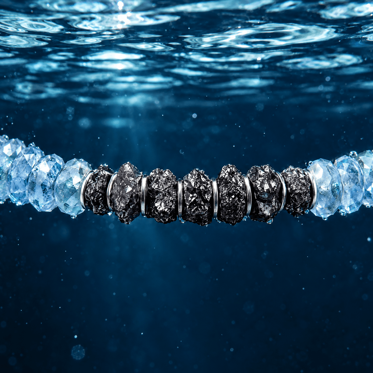 Underwater macro of Raw Black Diamond - Aquamarine Bracelet I (4mm), with blue faceted aquamarine and rough black diamonds beneath the water surface.