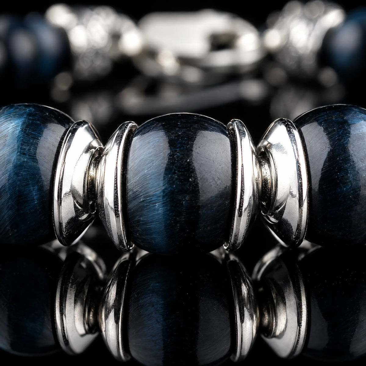 Macro detail of Blue Tiger Eye Bracelet IV (6.5mm), showing blue stone banding and paired sculpted silver spacers.